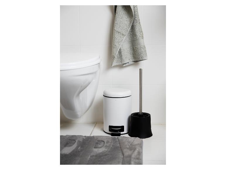 Eine weiße Toilettenbürste und ein weißer Mülleimer in einem Badezimmer.