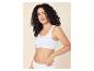 Frau mit lockigem Haar trägt einen weißen gerippten Bralette und passende Slips.