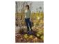 Frau in hellgrünem Rippstrickpullover, dunkelblauer Jeans und blauen Gummistiefeln im Freien.