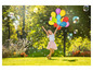 Ein Mädchen mit bunten Luftballons und Seifenblasen in einem Park.