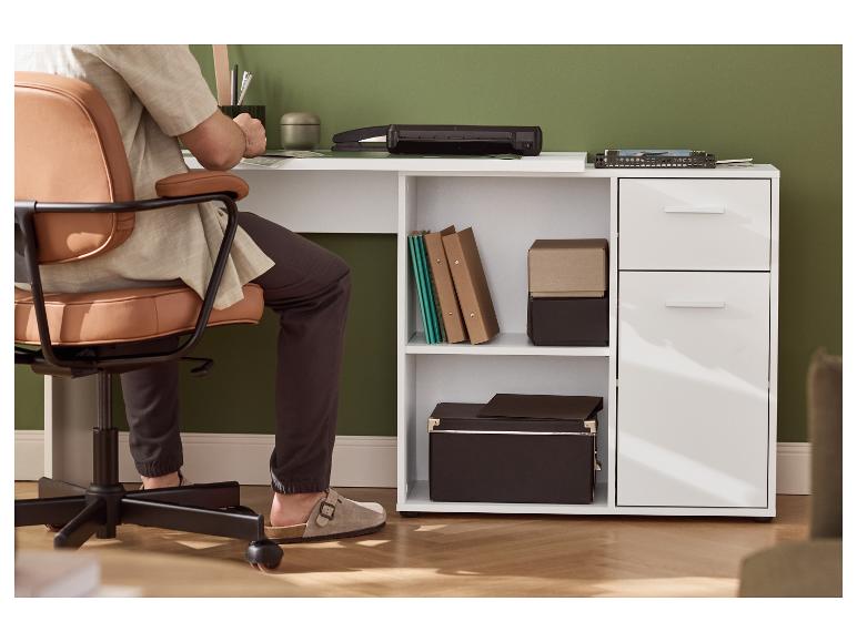 Person sitzt an einem weißen Schreibtisch mit Regalen, Schubladen und Büromaterial.
