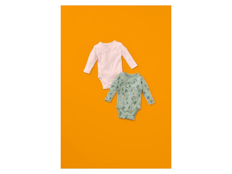 Zwei Baby-Bodys, ein hellrosa und ein mintgrüner mit Blumenmuster.
