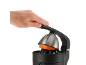 Nahaufnahme einer Hand, die eine Orange mit einer elektrischen Zitruspresse auspresst.