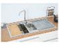 Edelstahl-Küchenspüle mit Holzschneidebrett und Abtropfgestell.