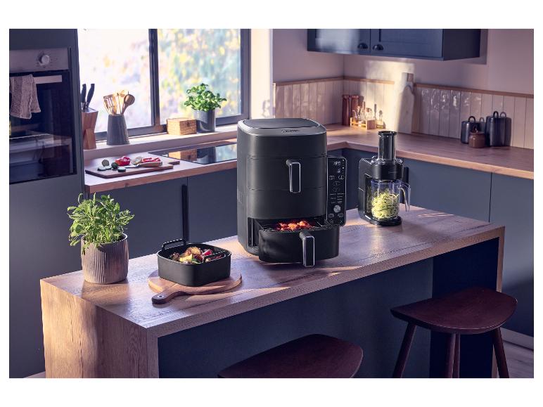 Küche mit einer Doppel-Heißluftfritteuse, einer Schale mit Essen und einem Spiralschneider.