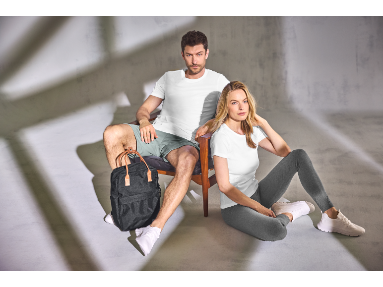 Mann und Frau in Sportkleidung mit einem schwarzen Rucksack.