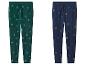 Zwei Jogginghosen, eine grüne mit Tannenbäumen und eine blaue mit Weihnachtsmotiven.