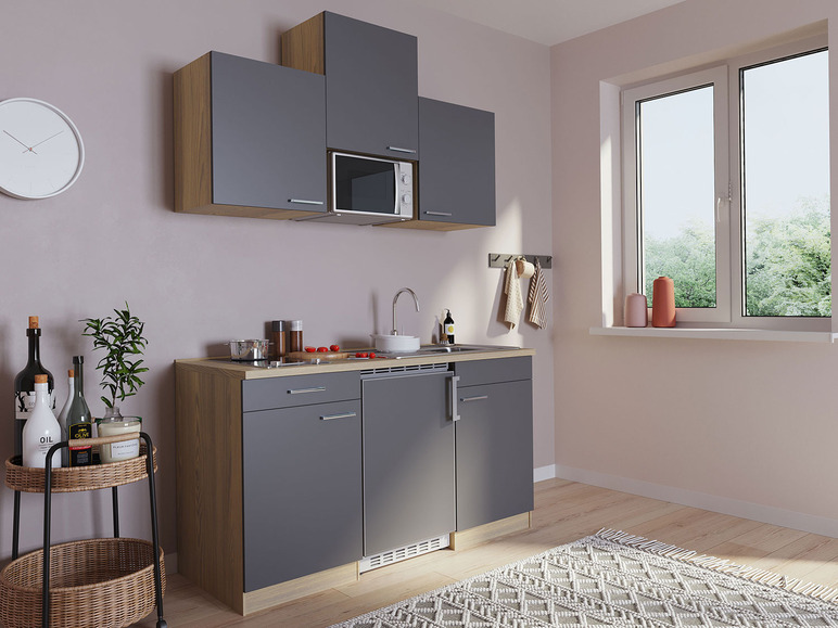 Küche mit grauen Schränken, einem eingebauten Mikrowellenherd und einem Waschbecken.