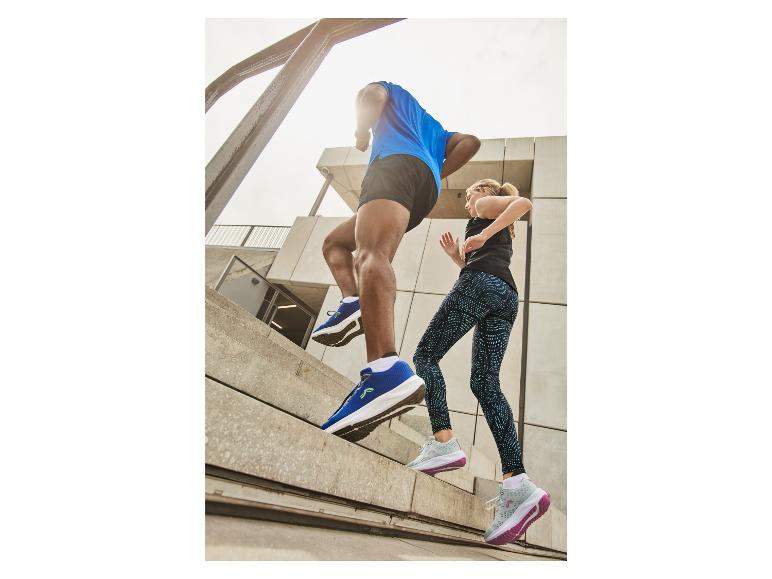 Zwei Personen rennen in der Stadt, tragen Sportkleidung und Sportschuhe.