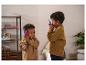 Zwei Jungen spielen mit roten und blauen Walkie-Talkies in einem Zimmer.