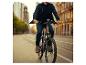 Mann in Jeans und Jacke fährt E-Bike auf einer Stadtstraße.