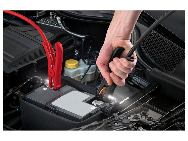 Hände schließen Überbrückungskabel an eine Autobatterie an.