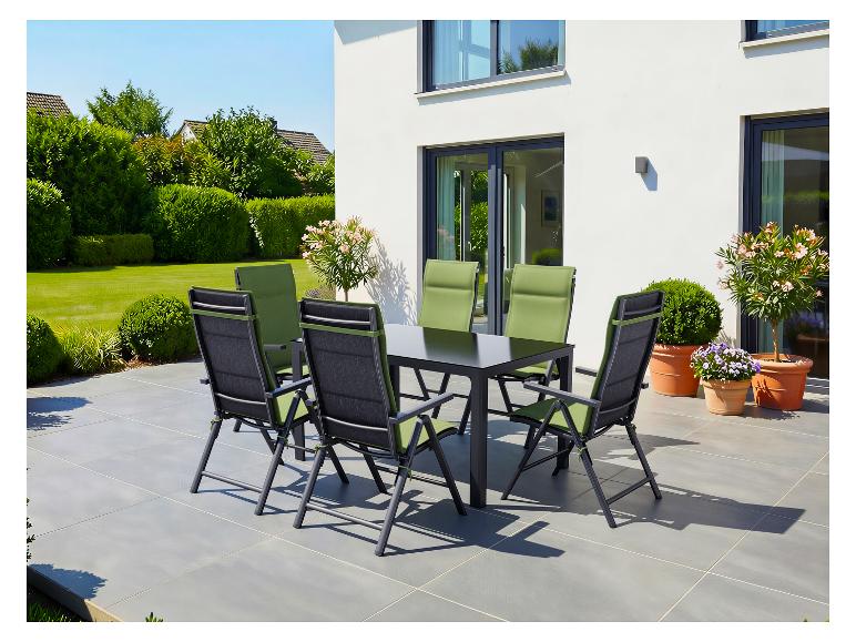 Gartenset mit schwarzem Tisch und grünen Stühlen auf einer Terrasse.
