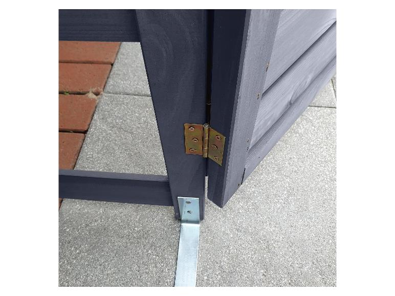 Ein Detail eines dunkelgrauen Holzzauns mit Scharnieren und einer Metallstütze.