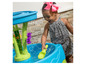 Ein Kind spielt mit einem Wasserspieltisch mit einer Fontäne und Schaufeln.