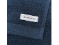 Dunkelblaues Handtuch mit einem weißen Etikett mit dem Text „TOM TAILOR“.