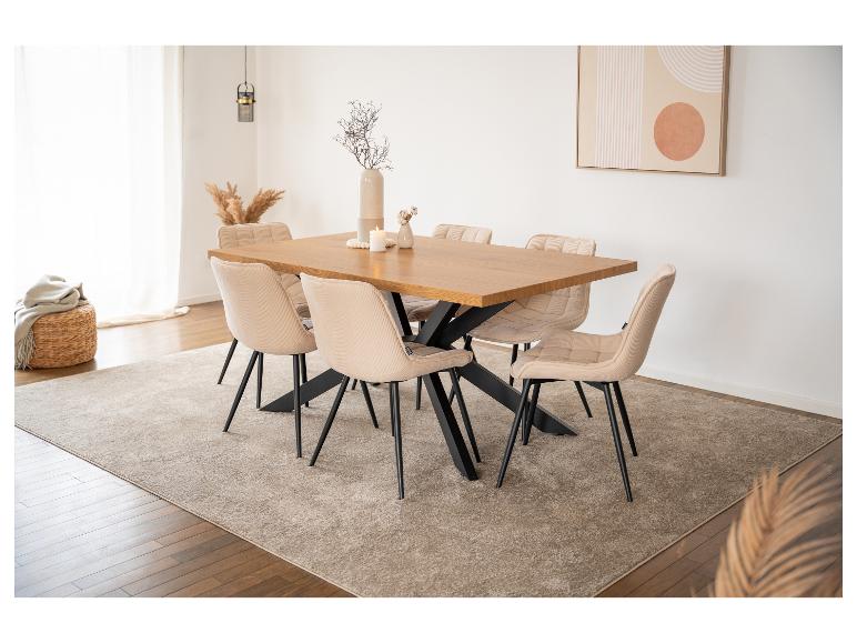 Holz-Esstisch mit sechs beigen Stühlen in einem hellen Esszimmer.