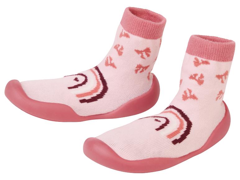 Ein Paar rosa Babysocken mit Gummisohle.