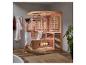 Frau im Handtuch vor einer HOME DELUXE Infrarotsauna aus Holz und Glas.