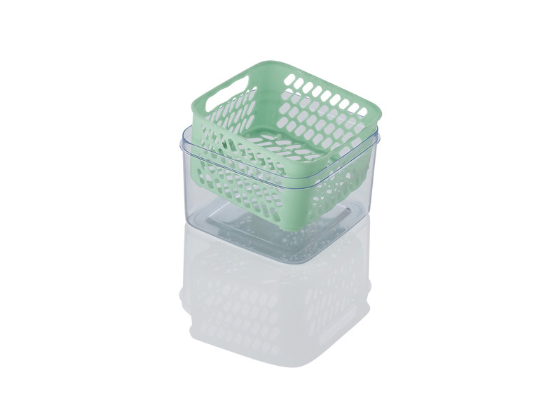 Ein grüner Plastikkorb auf einer transparenten Aufbewahrungsbox.