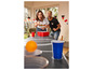 Zwei Personen spielen Bierpong mit einem orangefarbenen Ball und roten Bechern.