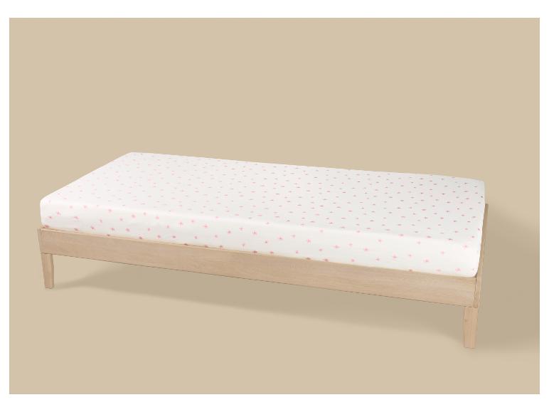 Helles Einzelbett aus Holz mit weißer Matratze und rosa Blumenmuster