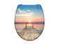 Toilettensitz mit einem Foto von einem Steg am Wasser bei Sonnenuntergang.