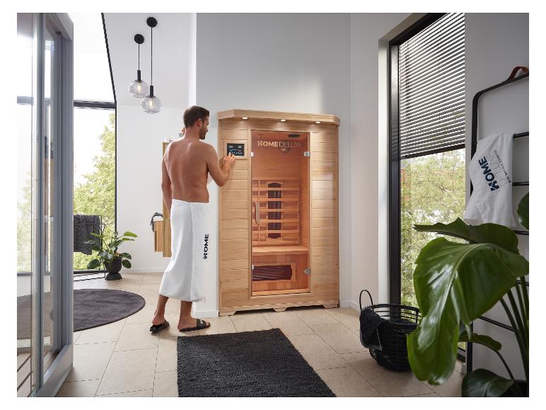 Home Deluxe: Heimsauna mit einem Mann, der die Bedienelemente einstellt, in einem modernen Badezimmer.