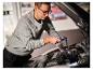 Mann benutzt LIVARNO® Arbeitsleuchte 'The Mechanic' zur Beleuchtung des Automotors.