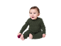 Glückliches Baby in grünem Rippenpyjama mit einer rosa Weihnachtskugel.