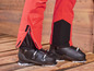 Rote Skibhose mit schwarzen Skischuhen.