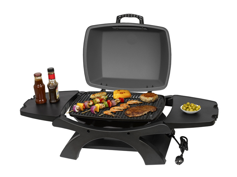 Ein Elektrogrill mit gegrilltem Fleisch, Garnelen und Gemüse.