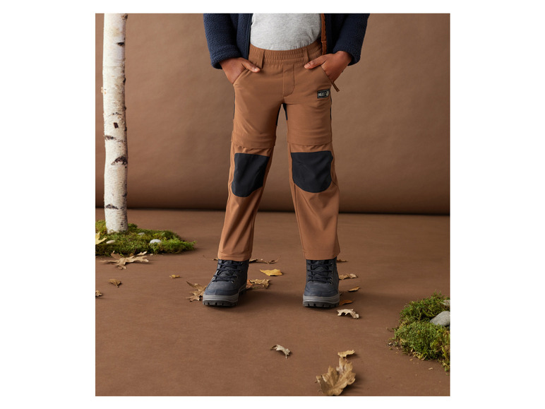 Braune Hose mit Knieschonern und schwarzen Stiefeln.