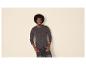 Mann mit Afro trägt ein dunkelgraues Langarm-Henley-Shirt und dunkle Jeans.