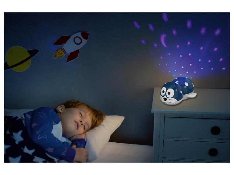 Ein Kind schläft in einem Bett mit einem Robben-Nachtlichtprojektor, der Sterne und Monde projiziert.