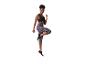 Frau in schwarzem Sport-BH und lila Capri-Leggings mit Leopardenmuster, im Sprung.