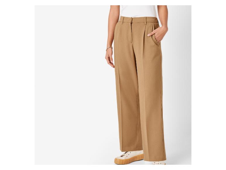 Beige weite Hose und flache Schuhe.