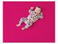 Baby in einem rosa Leopardenmuster-Trainingsanzug auf fuchsiafarbenem Hintergrund liegend.