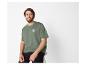 Mann in grünem T-Shirt mit „Summer Surf“-Aufdruck und schwarzer Hose.