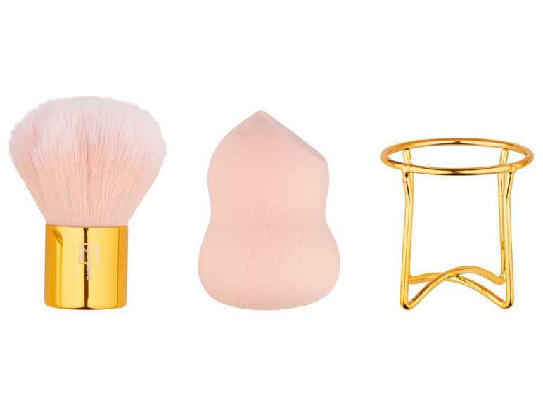 Ein Make-up-Pinsel, ein Schwamm und ein goldener Ständer.