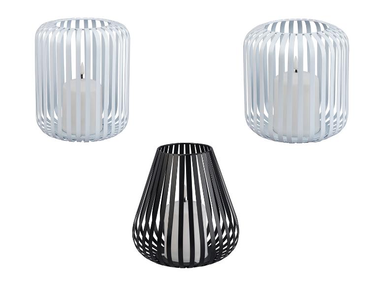 Zwei weiße und ein schwarzer Metall-Kerzenhalter mit Streifen.