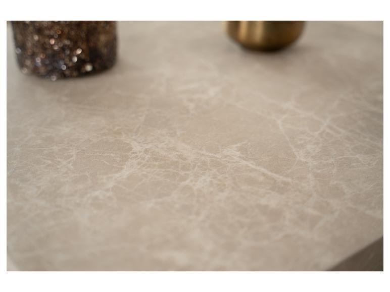 Beige Marmoroberfläche mit einer glitzernden Vase und einem goldenen Objekt unscharf im Hintergrund.