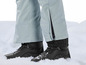 Schwarze Winterschuhe im Schnee mit hellblauen Skihosen
