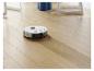 Ein Roboterstaubsauger auf einem Holzboden.