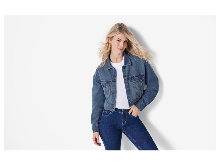 Eine Frau trägt eine Jeansjacke und Jeans.