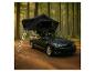 Auto mit Dachzelt und Leiter in einem Wald.
