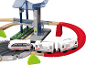 Spielzeugeisenbahn-Set mit weißem Zug, roten Gleisen und einem mehrstöckigen Bahnhof.