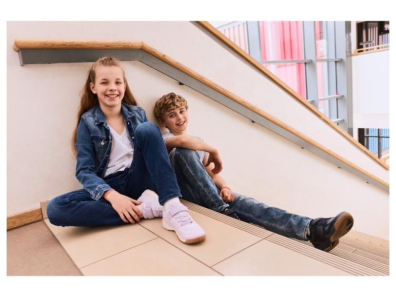 Zwei Kinder sitzen auf einer Treppe in CRIVIT Sportschuhen.