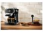 Kaffeemaschine mit zwei Espressotassen, Keksen und Kaffeebohnen auf der Arbeitsplatte.