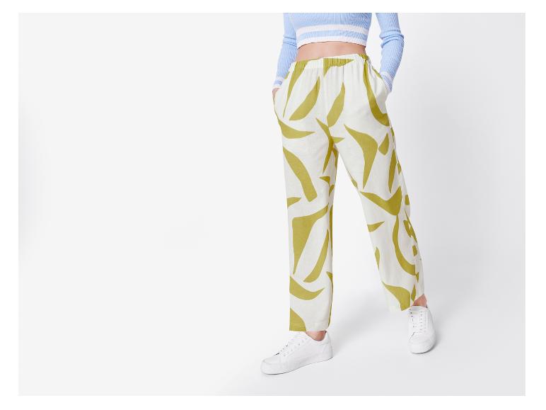 Weite Hose mit abstraktem Muster und weiße Turnschuhe.